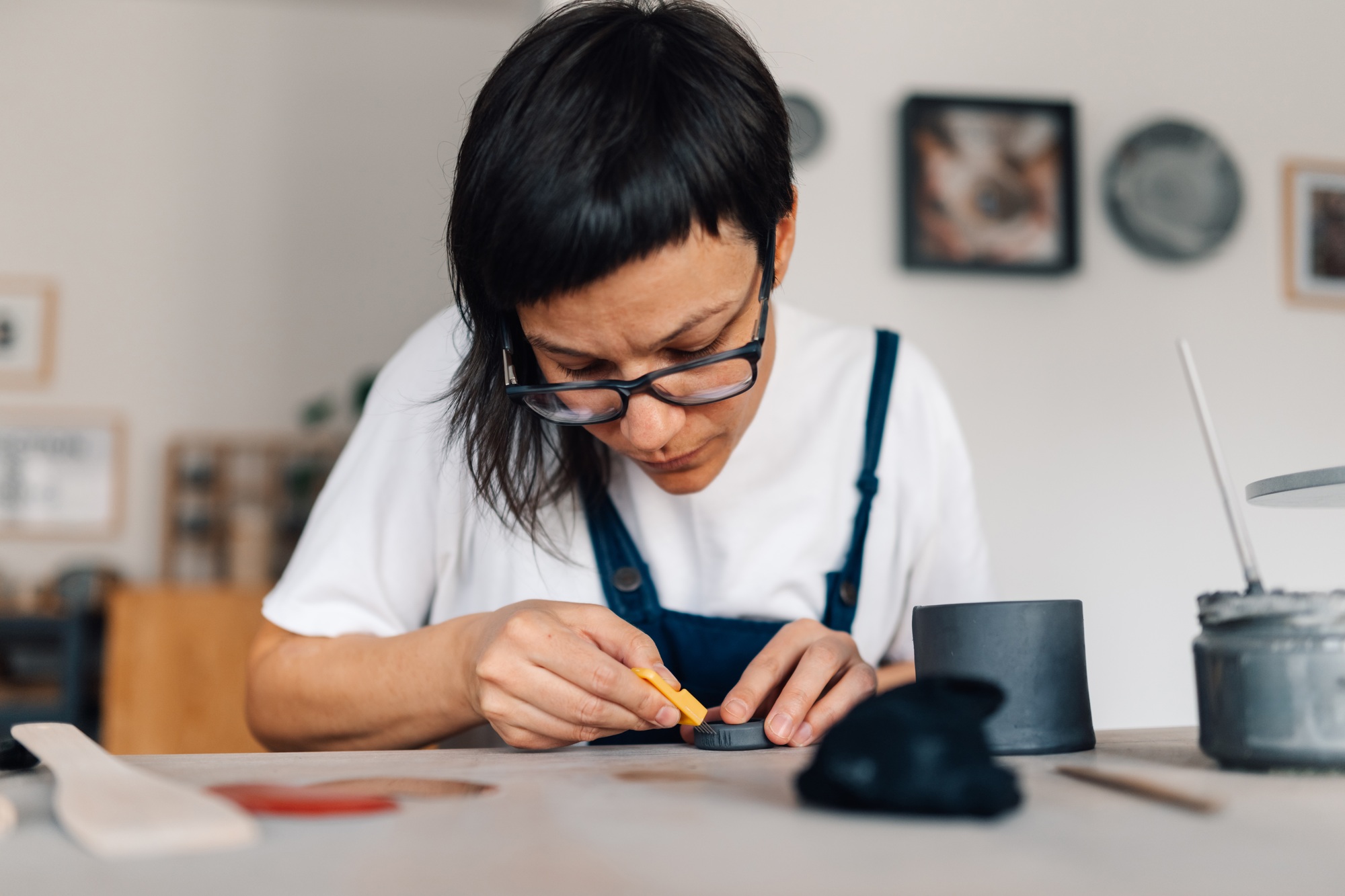 A ceramist working with pottery needles and wet clay at ceramics studio